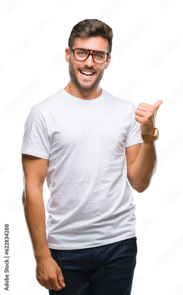 Wall mural young handsome man wearing glasses over isolated background smiling with happy face looking and poin