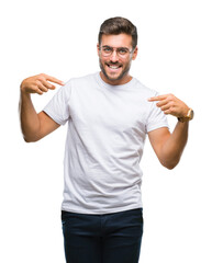 Young handsome man wearing glasses over isolated background looking confident with smile on face,...