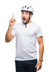 Young handsome man wearing cyclist safety helmet over isolated background pointing finger up with successful idea. Exited and happy. Number one.