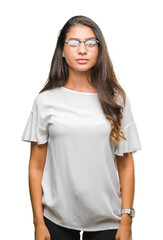 Young beautiful arab woman wearing glasses over isolated background with serious expression on face. Simple and natural looking at the camera.