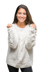 Young beautiful arab woman wearing winter sweater over isolated background celebrating surprised and amazed for success with arms raised and open eyes. Winner concept.