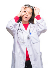 Young arab doctor woman over isolated background doing ok gesture shocked with surprised face, eye looking through fingers. Unbelieving expression.