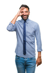 Adult hispanic business man over isolated background doing ok gesture with hand smiling, eye looking through fingers with happy face.