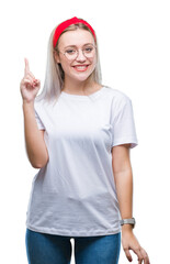 Young blonde woman wearing glasses over isolated background pointing finger up with successful idea. Exited and happy. Number one.