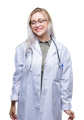Young blonde doctor woman over isolated background looking away to side with smile on face, natural expression. Laughing confident.