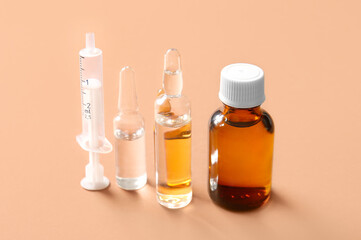Ampules, bottle with medicines and syringe on brown background