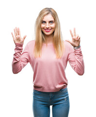 Fototapeta na wymiar Young beautiful blonde woman wearing pink winter sweater over isolated background showing and pointing up with fingers number eight while smiling confident and happy.