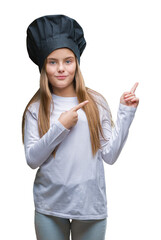 Young beautiful girl wearing chef hat uniform over isolated background smiling and looking at the camera pointing with two hands and fingers to the side.