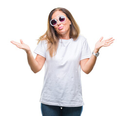Middle age hispanic woman wearing fashion sunglasses over isolated background clueless and confused...