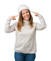 Fototapeta na wymiar Beautiful middle age woman wearing winter sweater and hat over isolated background Smiling pointing to head with both hands finger, great idea or thought, good memory