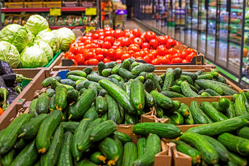 counter with fresh cucumbers, tomatoes, cabbage. Grocery store. Farming