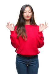 Obraz na płótnie Canvas Young asian woman wearing winter sweater over isolated background relax and smiling with eyes closed doing meditation gesture with fingers. Yoga concept.