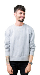 Fototapeta premium Young handsome man wearing sweatshirt over isolated background looking away to side with smile on face, natural expression. Laughing confident.