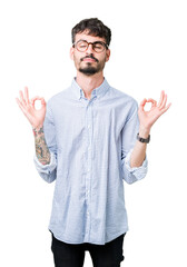 Naklejka premium Young handsome man wearing glasses over isolated background relax and smiling with eyes closed doing meditation gesture with fingers. Yoga concept.