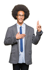 Young african american business man with afro hair wearing glasses Swearing with hand on chest and...