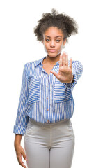 Young afro american woman over isolated background doing stop sing with palm of the hand. Warning expression with negative and serious gesture on the face.