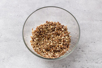 Glass bowl with mix of oatmeal, nuts, coconut sugar and dates on gray textured background, top view. Cooking delicious healthy oatmeal cookies - 622841227