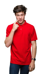 Young handsome man wearing red t-shirt over isolated background Pointing with hand finger to face and nose, smiling cheerful