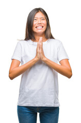 Young asian woman over isolated background begging and praying with hands together with hope expression on face very emotional and worried. Asking for forgiveness. Religion concept.