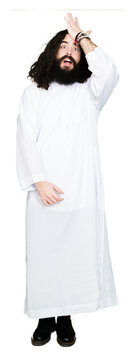 Man wearing Jesus Christ costume surprised with hand on head for mistake, remember error. Forgot, bad memory concept.