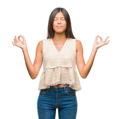 Young asian woman over isolated background relax and smiling with eyes closed doing meditation gesture with fingers. Yoga concept.