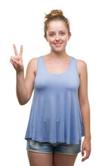 Young blonde woman showing and pointing up with fingers number two while smiling confident and happy.