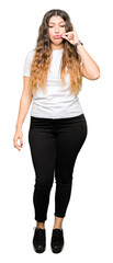 Young beautiful woman wearing casual white t-shirt mouth and lips shut as zip with fingers. Secret...