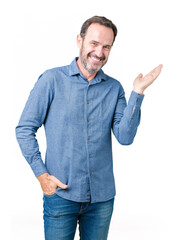 Handsome middle age elegant senior man over isolated background smiling cheerful presenting and pointing with palm of hand looking at the camera.
