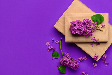 Beautiful lilac flowers and books on purple background © Pixel-Shot