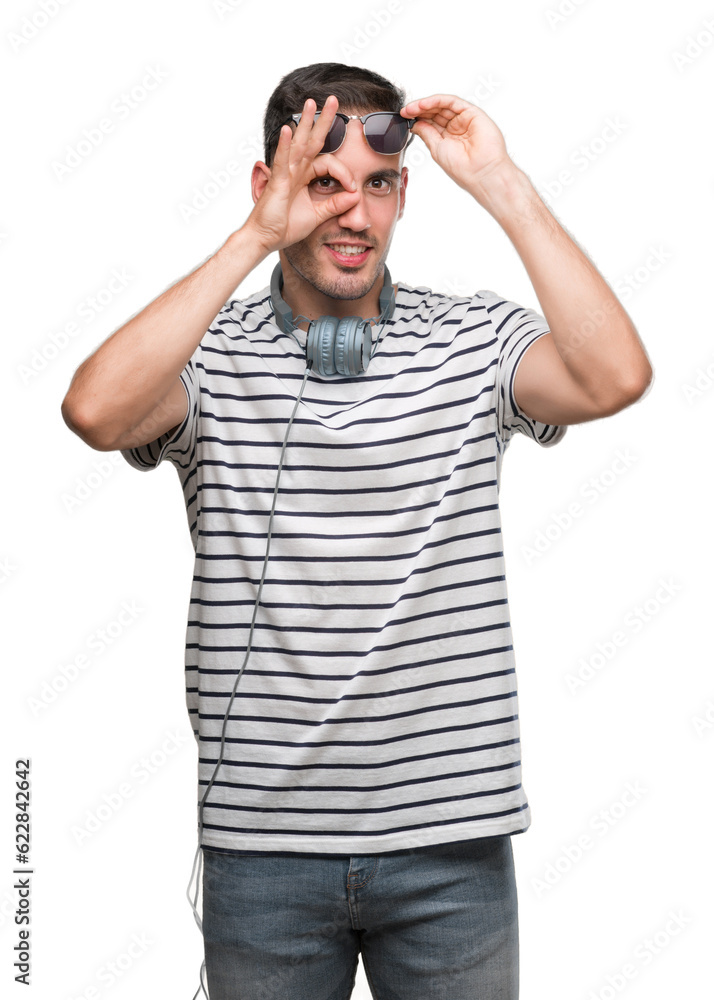 Sticker handsome young man wearing headphones doing ok gesture with hand smiling, eye looking through finger