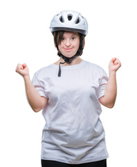 Young adult cyclist woman with down syndrome wearing safety helmet over isolated background celebrating mad and crazy for success with arms raised and closed eyes screaming excited. Winner concept