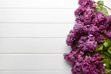 Beautiful lilac flowers on light wooden background