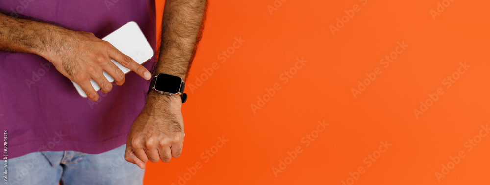 Aufkleber Unrecognizable dark-skinned man using application on smartphone and smart watch
