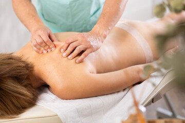 Obraz na płótnie Canvas massage therapist doing a back massage to a woman close-up