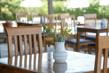 Empty wooden tables before dinner time in the charming outdoor restaurant	