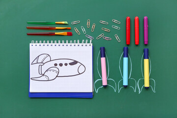 Creative composition with rockets and different stationery on green chalkboard © Pixel-Shot