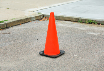 Vibrant orange construction cones line the street, symbolizing progress, caution, and temporary...