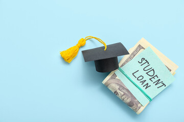 Dollar banknotes, graduation cap and sticky note with text STUDENT LOAN on blue background