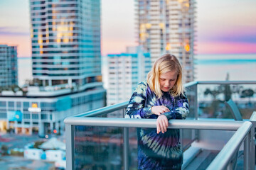 Boy standing on balcony admiring the view from a highrise apartment in Surfers Paradise on the Gold Coast, Queensland Australia