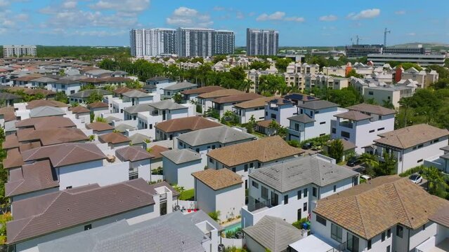 Drone view of traditional american residential houses at summertime with city skyscrapers on background. Suburb and urbanization concept