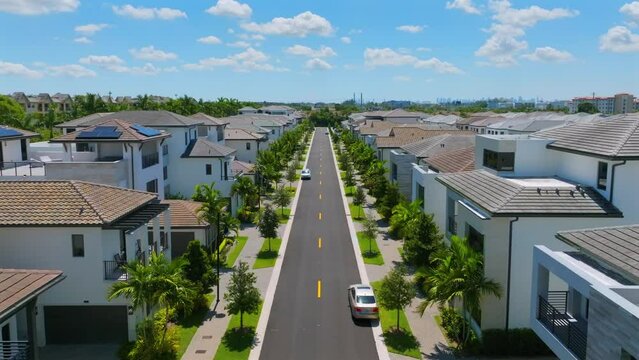 Luxury upscale residential neighborhood gated community street in Miami. American suburb with single family houses with landscaping design. Aerial view