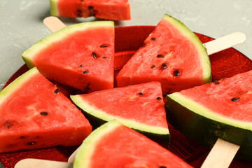 Plate with sweet watermelon sticks on grey background, closeup