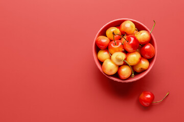Bowl with sweet yellow cherries on red background