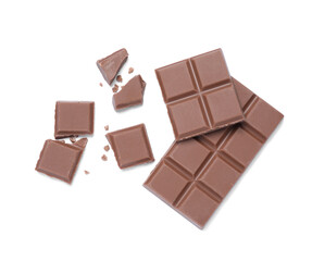 Pieces of delicious milk chocolate bar on white background, top view