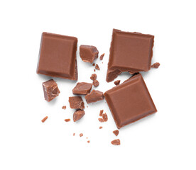 Pieces of delicious milk chocolate bar on white background, top view