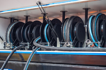 Reels with black hoses. Fuel transfer equipment. Rubber hoses with traces of dirt. Refueling...