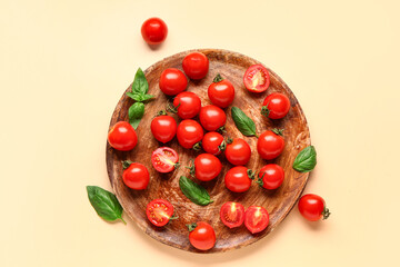 Wooden board with fresh cherry tomatoes and basil on orange background