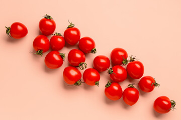 Many fresh cherry tomatoes on pink background