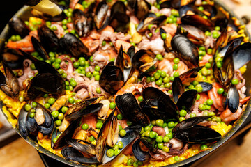 Spanish seafood paella with mussels and shrimps close-up view.