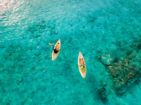 Aerial view of Kayakers on crystal clear blue ocean, Baa Atoll, Maldives.